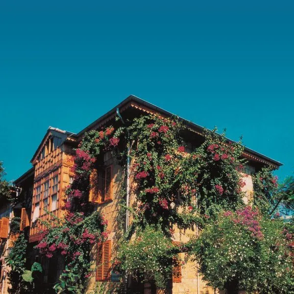 Tradicionalna kamnita zgradba Begonville Pansiyon s cvetočimi bugenvilijami v Sideju.