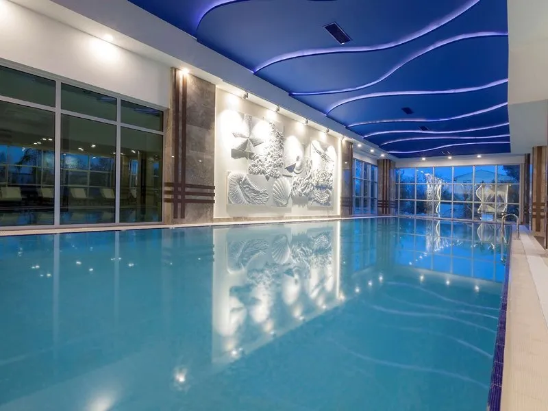 Luksuzen notranji bazen z modro osvetlitvijo v wellness centru