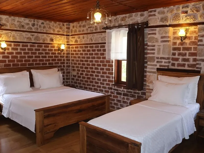 Udobna hotelska soba z avtentičnimi opečnatimi stenami in lesenim pohištvom