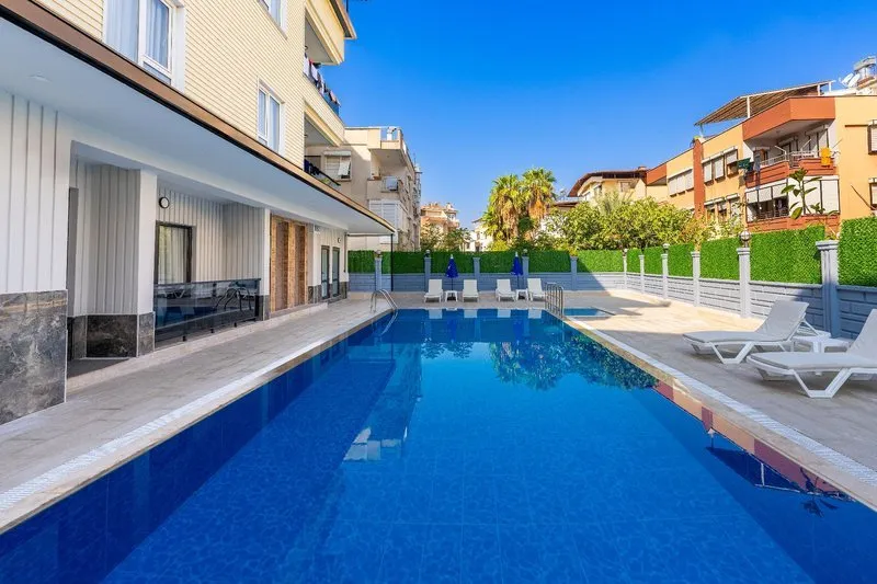 Zunanji bazen z modro vodo in ležalniki