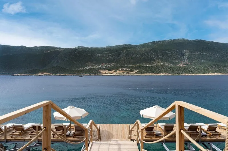 Lesena ploščad za sončenje z ležalniki in direktnim pogledom na morje