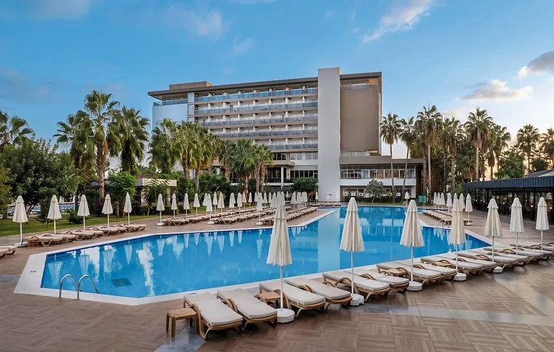 Velik zunanji bazen hotela Royal Garden Beach z ležalniki in palmami