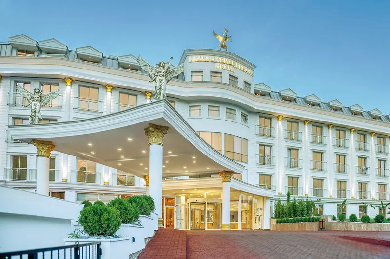 Veličastna zunanjost hotela Sealife Kemer Resort z belo fasado in kipi