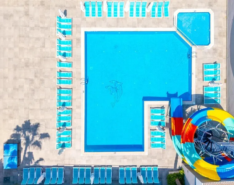 Pogled iz zraka na modri bazen in ležalnike